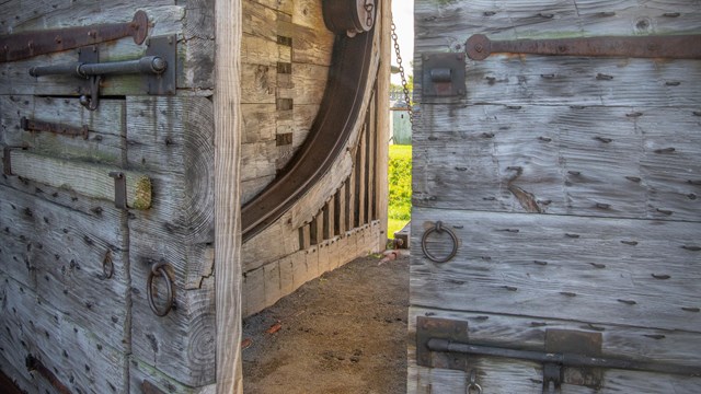 A large wooden door stands partially open in front of you. 